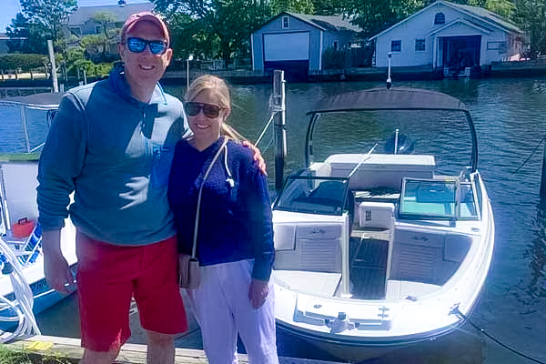 Couple posing near boat on dock